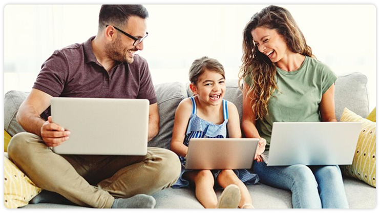 משפחה עם מחשבים ניידים על הספה